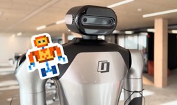 A humanoid robot with a camera-equipped head in an office, alongside Mistral AI's pixel-art robot mascot