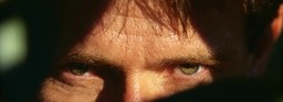 Extreme close-up frame of a human face generated by LTX-2.5, showing forehead and eyes in hard directional light with visible skin pore and hair detail.