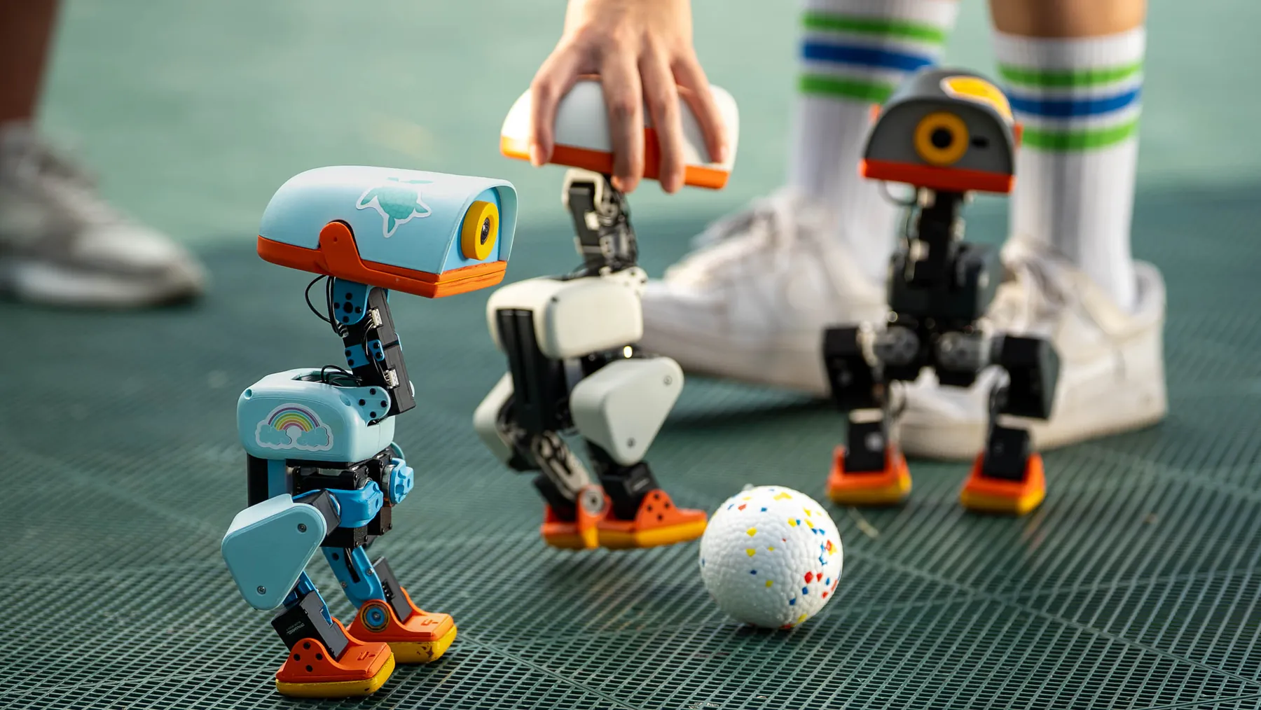 Microduck robot pushing a small ball across a floor
